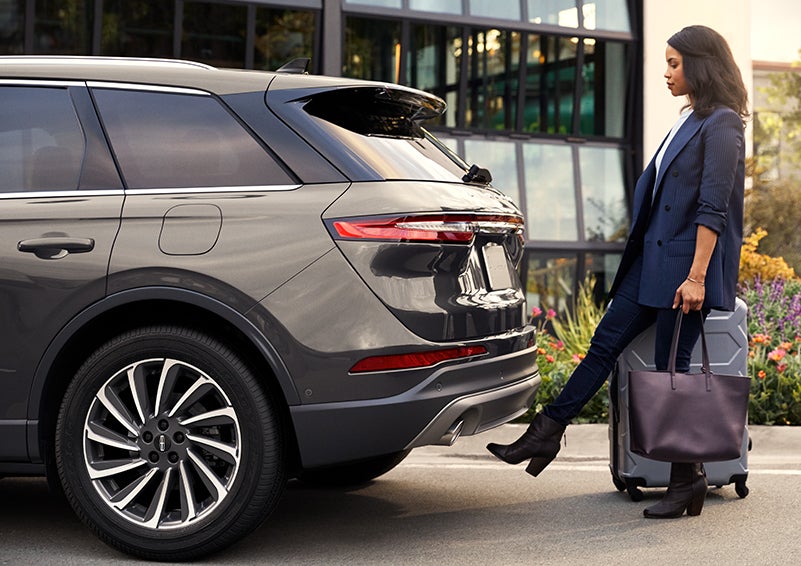 A woman with her hands full uses her foot to activate the available hands-free liftgate. | Bayway Lincoln in Houston TX